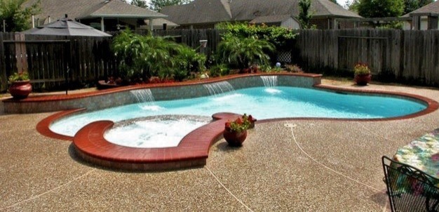 Inspiration for a large modern backyard custom-shaped pool in Houston with a water feature and stamped concrete.