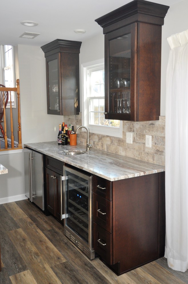 Small modern galley wet bar in DC Metro with shaker cabinets, dark wood cabinets, granite benchtops and vinyl floors.