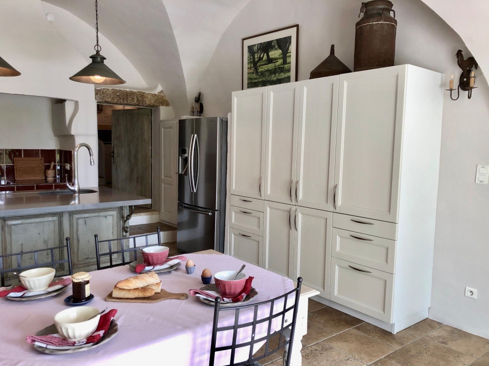 Photo of a small galley kitchen in Other with an undermount sink, shaker cabinets, white cabinets, quartzite benchtops, red splashback, ceramic splashback, stainless steel appliances, limestone floors, with island, beige floor, grey benchtop and vaulted.