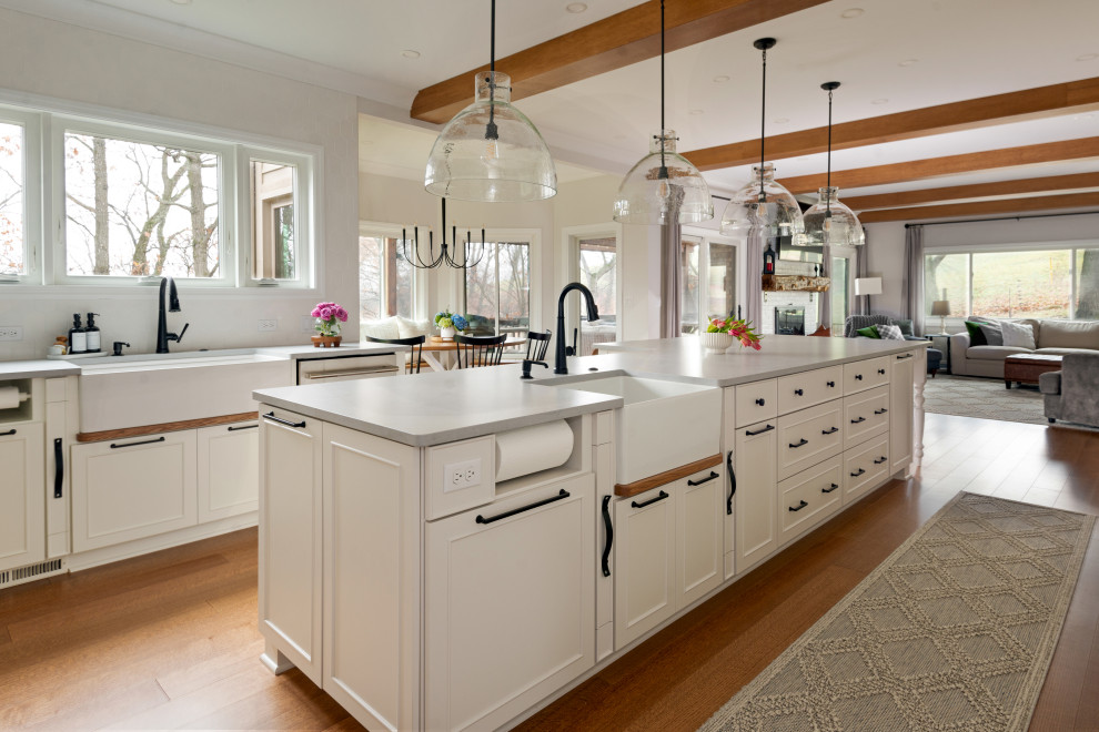 Eat-in kitchen - large medium tone wood floor and exposed beam eat-in kitchen idea with white backsplash, stainless steel appliances and an island