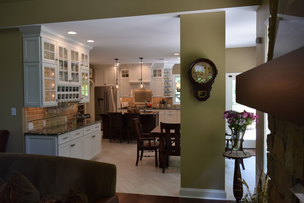 Transitional ceramic tile and gray floor kitchen photo with an undermount sink, recessed-panel cabinets, white cabinets, quartz countertops, beige backsplash, subway tile backsplash, stainless steel appliances and an island