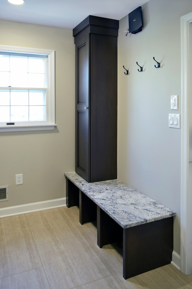 Photo of a mid-sized transitional u-shaped utility room in Philadelphia with an undermount sink, recessed-panel cabinets, dark wood cabinets, granite benchtops, beige walls, vinyl floors, a side-by-side washer and dryer, beige floor and multi-coloured benchtop.