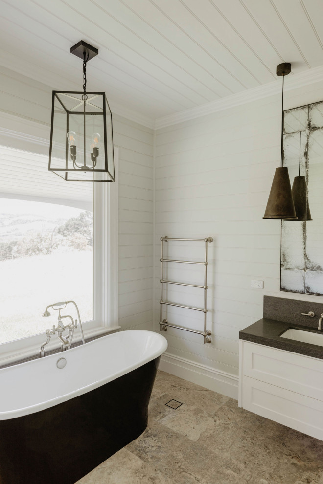Пример оригинального дизайна: главная ванная комната в стиле кантри с белыми фасадами, отдельно стоящей ванной, угловым душем, врезной раковиной, открытым душем, тумбой под одну раковину, подвесной тумбой и панелями на части стены