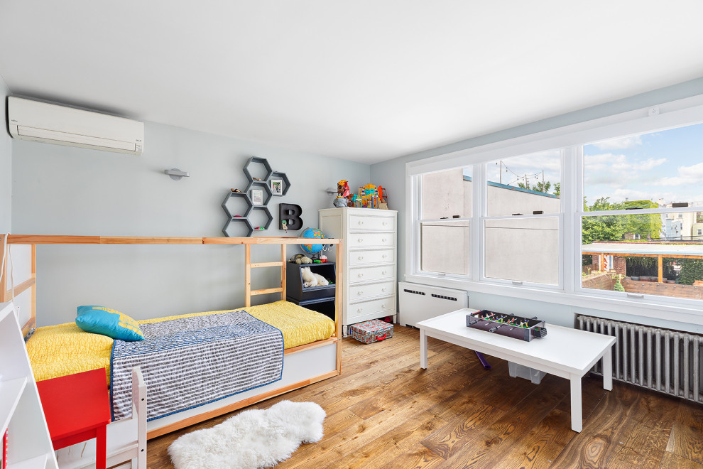 This is an example of a transitional kids' bedroom for kids 4-10 years old and boys in New York with grey walls, medium hardwood floors and brown floor.