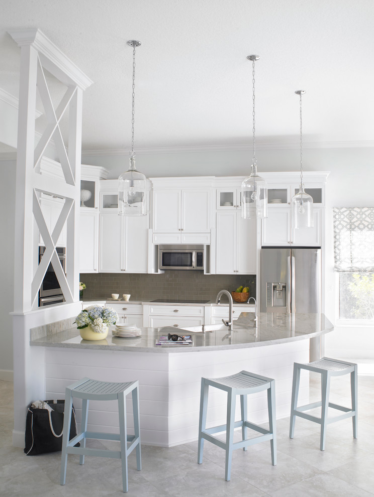Mid-sized transitional l-shaped open concept kitchen photo in Miami with a farmhouse sink, recessed-panel cabinets, white cabinets, beige backsplash, subway tile backsplash, stainless steel appliances, an island and quartzite countertops