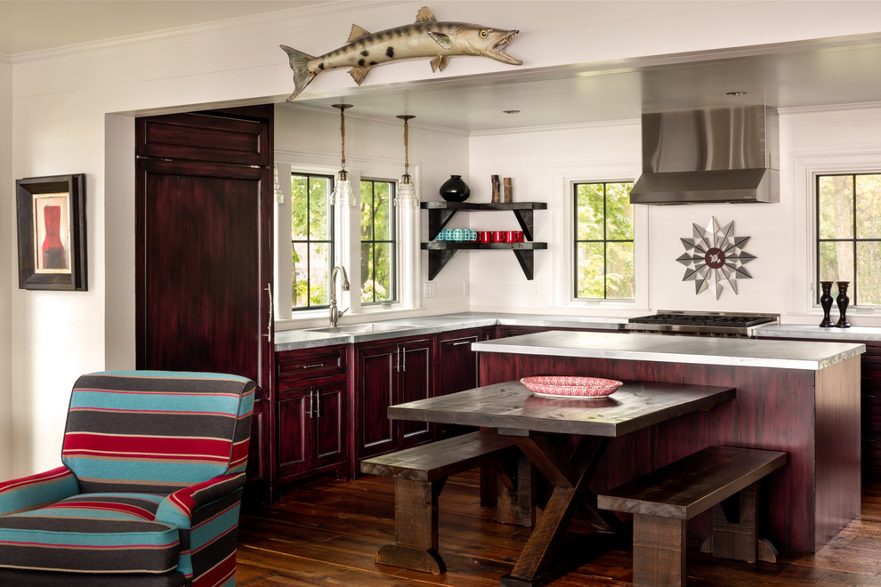 This is an example of a mid-sized beach style l-shaped open plan kitchen in Milwaukee with recessed-panel cabinets, stainless steel benchtops, white splashback, panelled appliances, dark hardwood floors, with island, an integrated sink and dark wood cabinets.