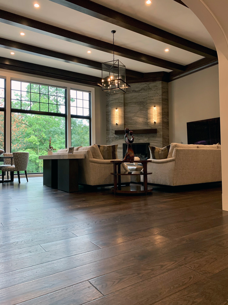 Photo of an expansive traditional open concept living room in Chicago with dark hardwood floors, a corner fireplace, a stone fireplace surround, brown floor and exposed beam.