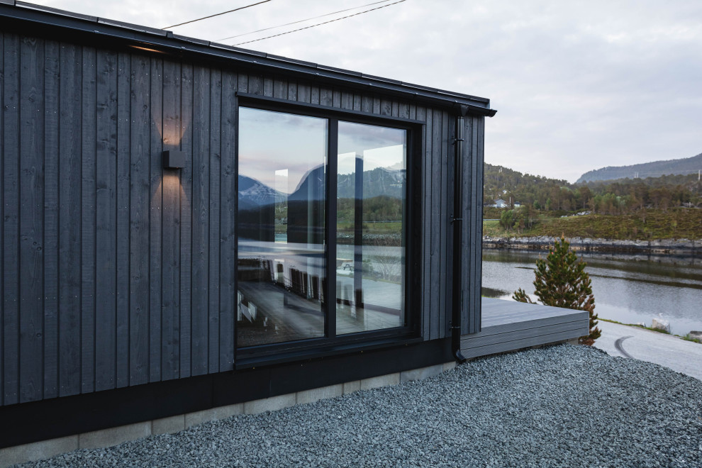 Inspiration för mellanstora minimalistiska trähus, med allt i ett plan, pulpettak och tak i metall