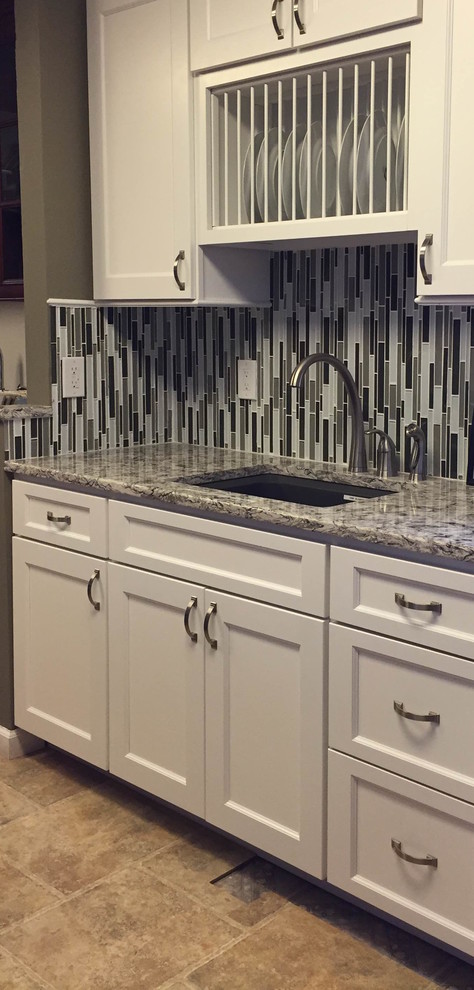 Example of a mid-sized transitional ceramic tile kitchen design in Orange County with an undermount sink, shaker cabinets, white cabinets, granite countertops, multicolored backsplash, matchstick tile backsplash, stainless steel appliances and an island