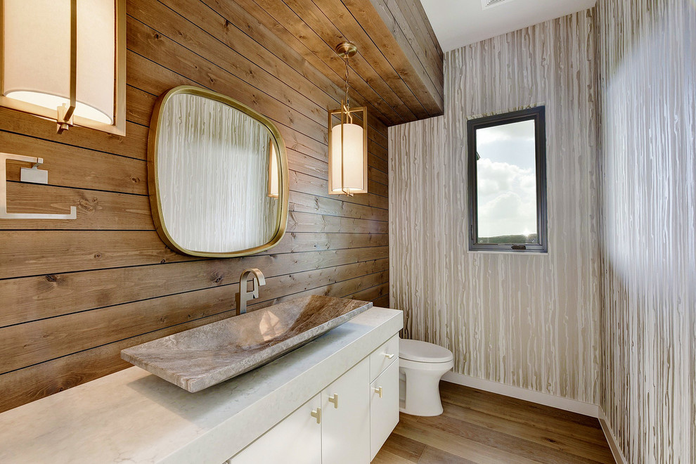Contemporary powder room in Austin with flat-panel cabinets, white cabinets, brown tile, brown walls, a vessel sink, brown floor and white benchtops.