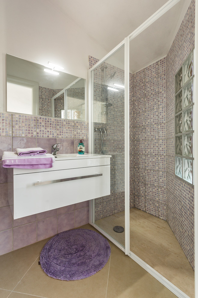 This is an example of a mid-sized contemporary 3/4 bathroom in Cagliari with flat-panel cabinets, white cabinets, a curbless shower, mosaic tile, white walls, an integrated sink and gray tile.