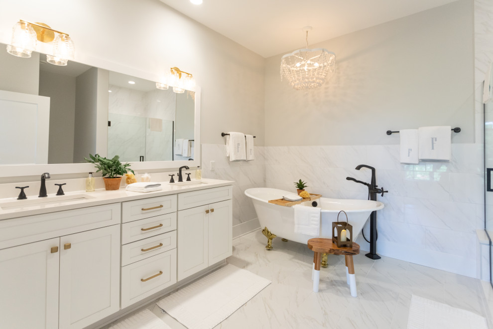This is an example of a transitional bathroom in Baltimore with shaker cabinets, white cabinets, a claw-foot tub, white tile, grey walls, an undermount sink, white floor, white benchtops, a double vanity and a built-in vanity.