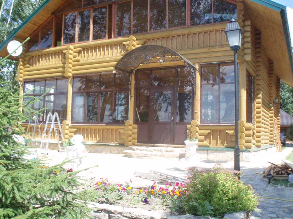 Двухэтажный дом из бревна с большими окнами