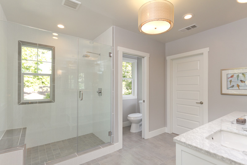 Design ideas for a mid-sized traditional 3/4 bathroom in Sacramento with an undermount sink, shaker cabinets, white cabinets, marble benchtops, a two-piece toilet, gray tile, ceramic tile, grey walls, ceramic floors and an alcove shower.