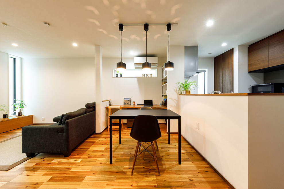 This is an example of a mid-sized industrial open plan dining in Tokyo Suburbs with white walls, dark hardwood floors, brown floor, wallpaper and wallpaper.