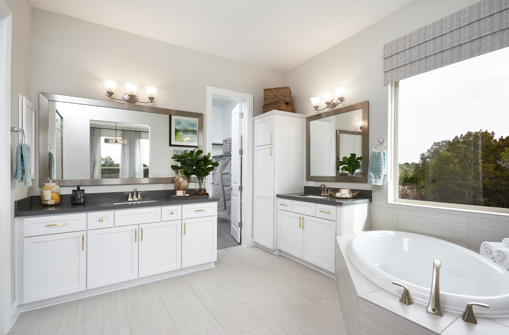 Large contemporary master bathroom in Austin with recessed-panel cabinets, a drop-in tub, an alcove shower, beige tile, ceramic tile, beige walls, ceramic floors, an undermount sink, solid surface benchtops, beige floor, a hinged shower door and grey benchtops.
