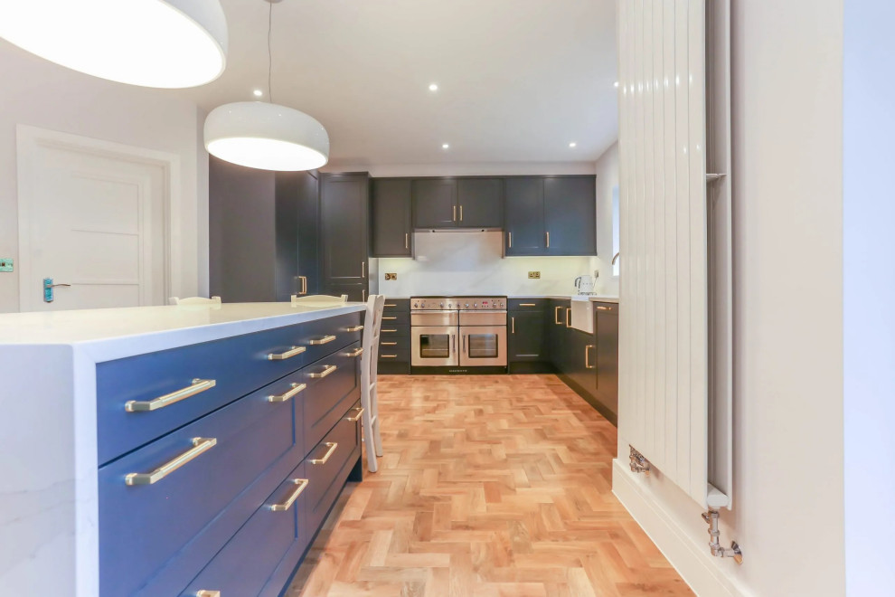 Design ideas for a large contemporary u-shaped eat-in kitchen in London with a drop-in sink, beaded inset cabinets, blue cabinets, copper benchtops, blue splashback, timber splashback, stainless steel appliances, ceramic floors, with island, brown floor, brown benchtop and wood.