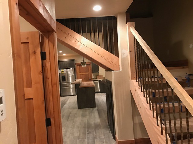 This is an example of a mid-sized country l-shaped staircase in Denver with open risers and mixed railing.