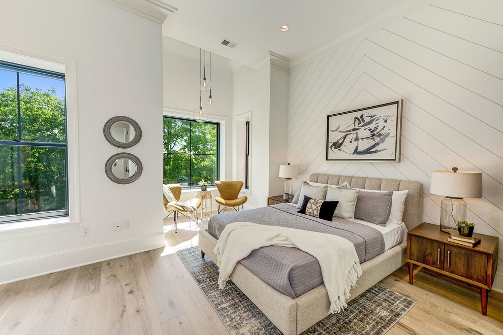 This is an example of a transitional guest bedroom in DC Metro with white walls, light hardwood floors and beige floor.