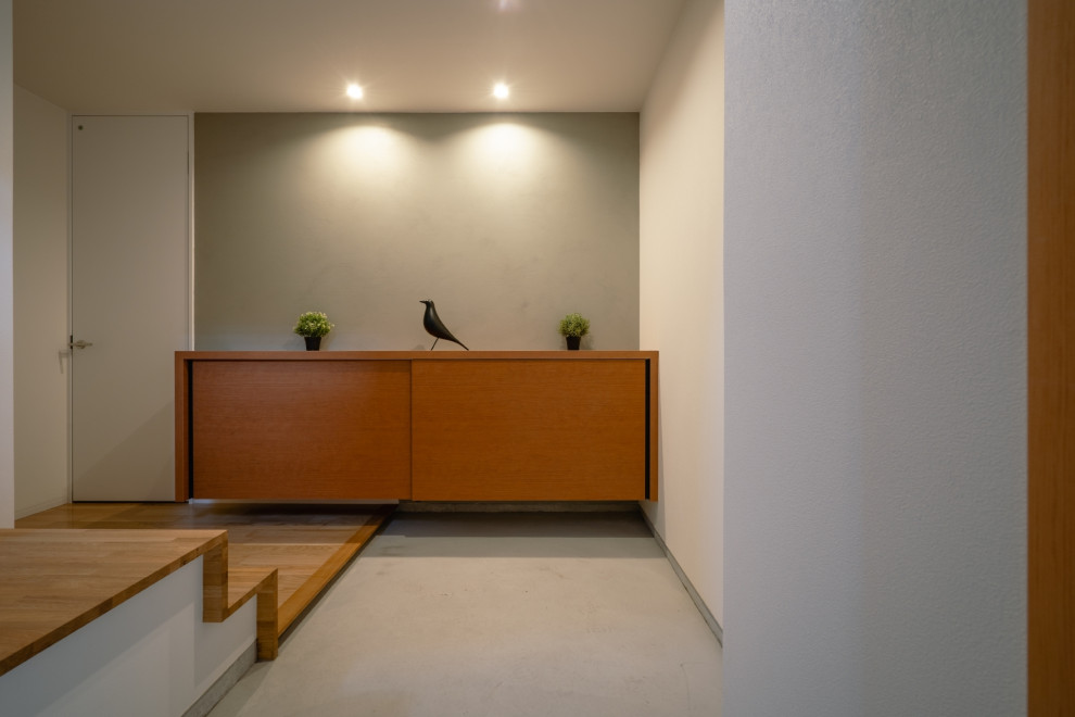 Idées déco pour une entrée moderne avec un couloir, un mur gris, sol en béton ciré, une porte simple, une porte en bois brun, un sol gris, un plafond en papier peint et du papier peint.