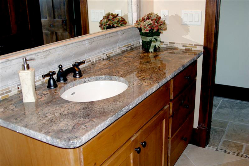 Example of a small transitional beige tile and stone tile travertine floor bathroom design in Denver with medium tone wood cabinets, beige walls, an undermount sink, granite countertops and recessed-panel cabinets