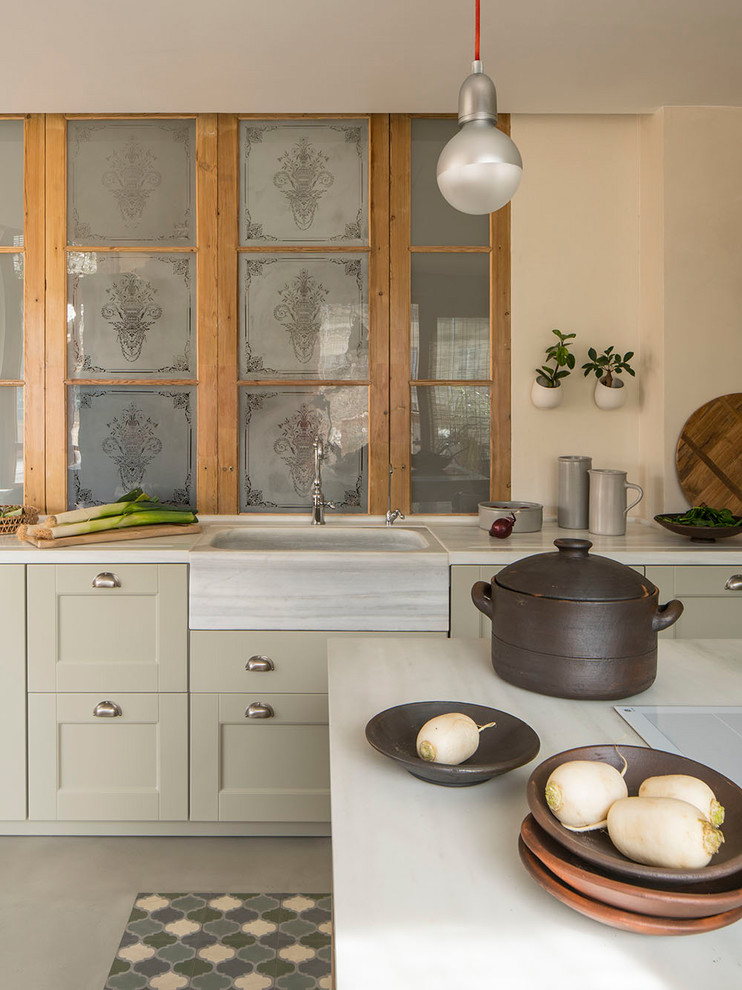 Mid-sized mediterranean l-shaped open plan kitchen in Barcelona with a drop-in sink, raised-panel cabinets, beige cabinets, granite benchtops, grey splashback, limestone splashback, panelled appliances, porcelain floors, with island, multi-coloured floor and grey benchtop.