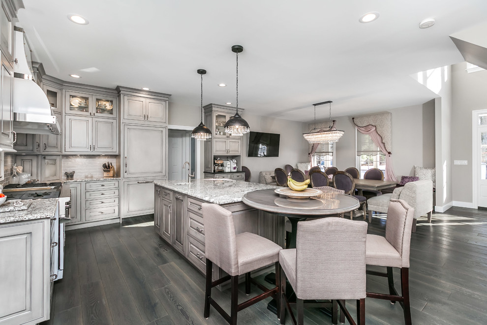 Design ideas for a large traditional u-shaped eat-in kitchen in Baltimore with a farmhouse sink, beaded inset cabinets, grey cabinets, granite benchtops, grey splashback, white appliances, medium hardwood floors, with island and grey floor.