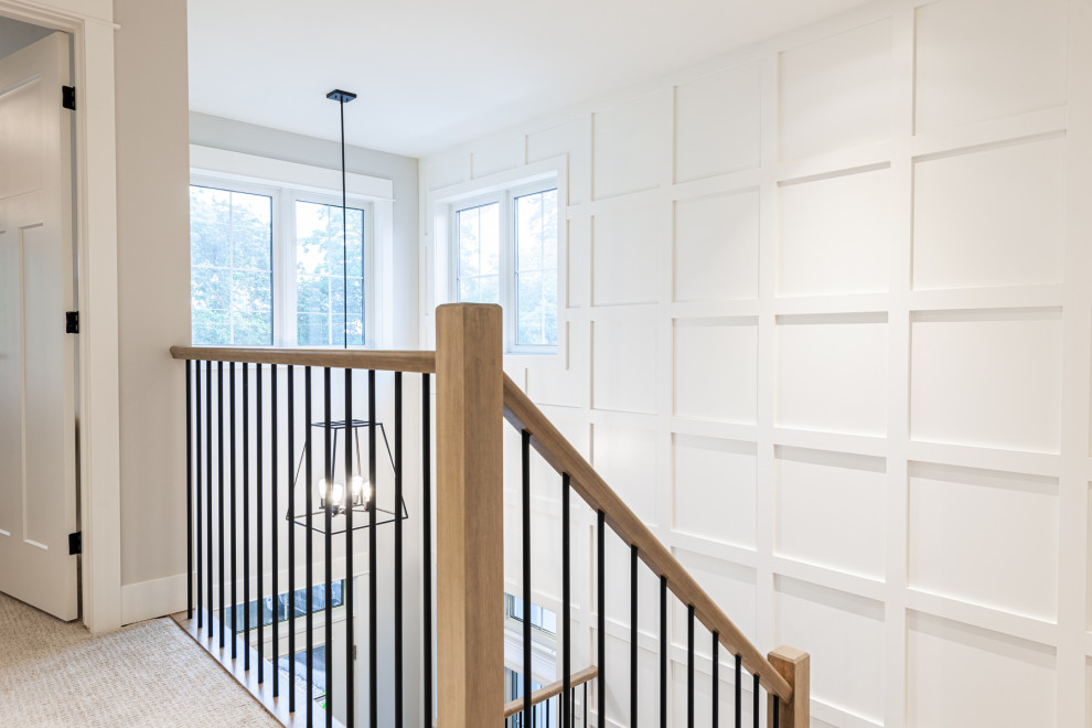 Mid-sized transitional wooden u-shaped wood railing and wall paneling staircase photo in Toronto with wooden risers