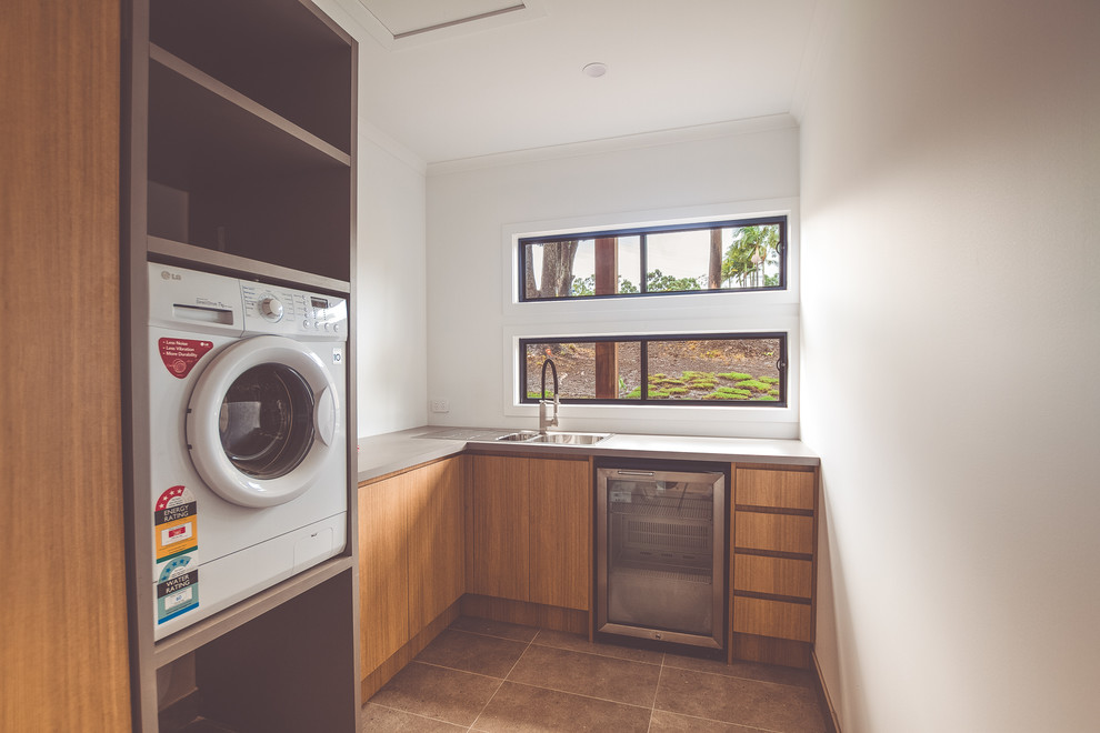 Photo of a mid-sized modern l-shaped dedicated laundry room in Sunshine Coast with a double-bowl sink, flat-panel cabinets, light wood cabinets, white walls and medium hardwood floors.