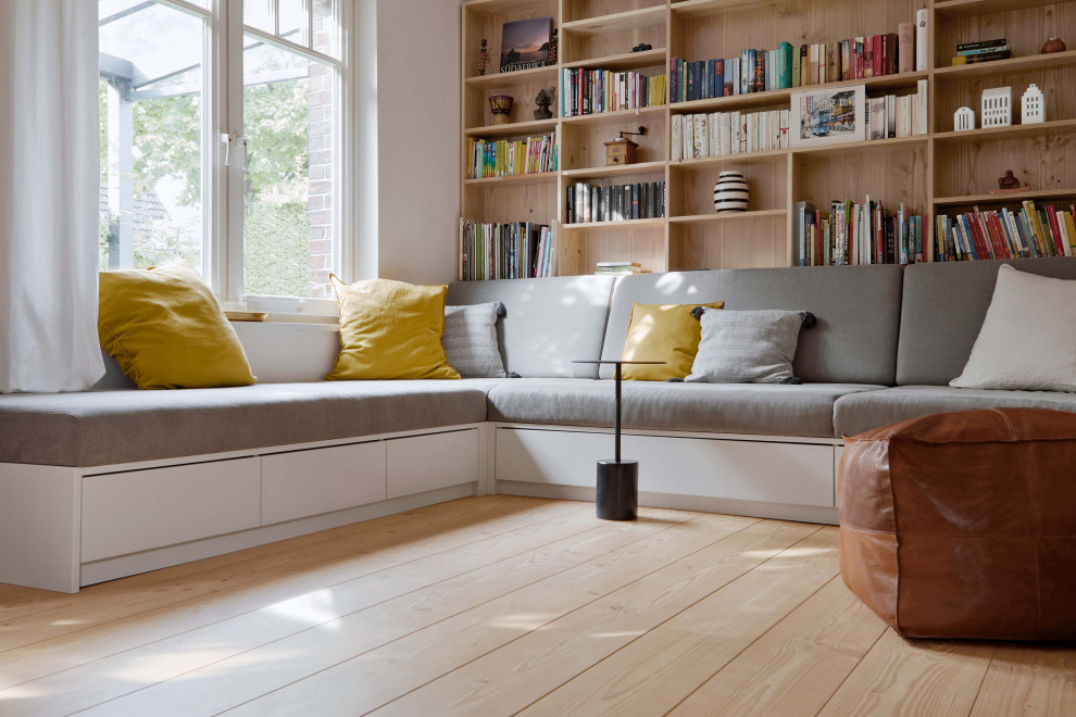 Ejemplo de sala de estar abierta nórdica con suelo de madera clara y vigas vistas