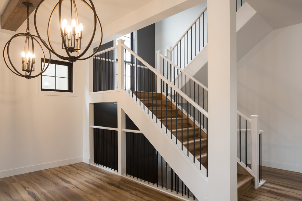 Design ideas for a large transitional wood u-shaped staircase in Calgary with wood risers and mixed railing.