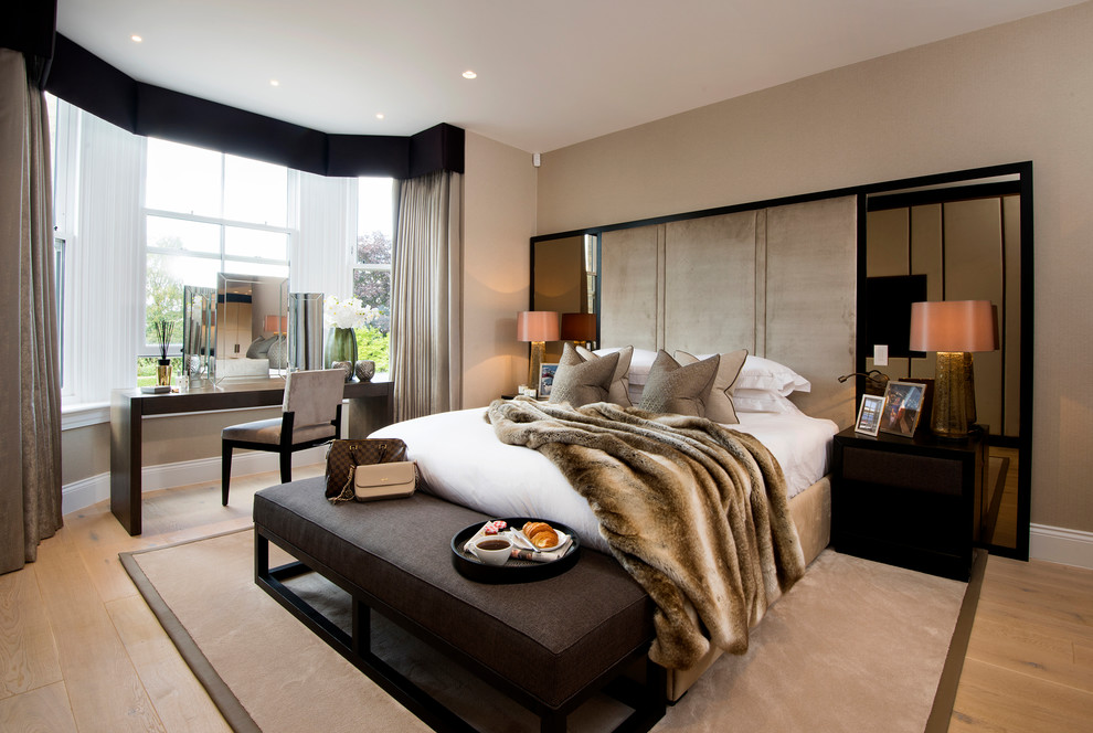 Photo of a contemporary bedroom in Manchester with beige walls, light hardwood floors and beige floor.