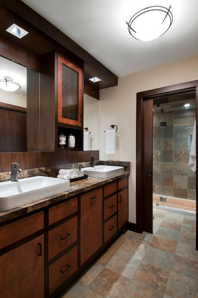 Photo of a large contemporary bathroom in San Francisco with a vessel sink, medium wood cabinets, marble benchtops, a one-piece toilet, multi-coloured tile, beige walls, slate floors, slate and flat-panel cabinets.
