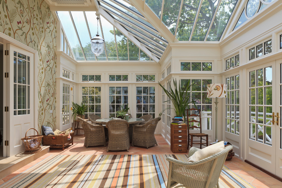 Photo of a large traditional sunroom in Channel Islands with terra-cotta floors, no fireplace and a glass ceiling.
