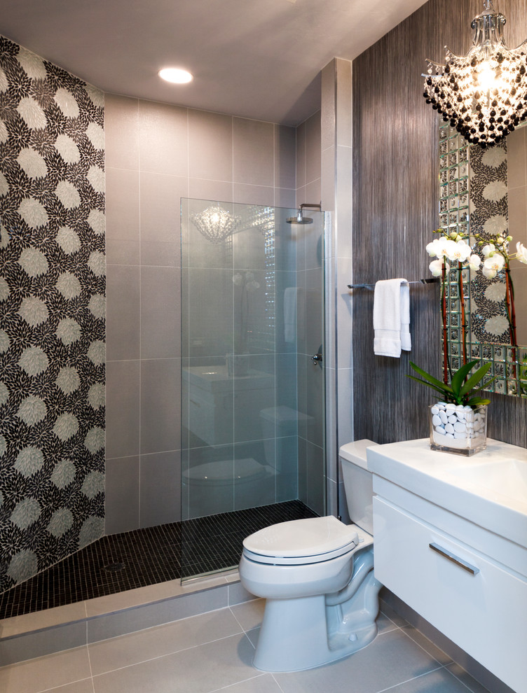Design ideas for a mid-sized contemporary 3/4 bathroom in Minneapolis with an integrated sink, furniture-like cabinets, white cabinets, engineered quartz benchtops, a corner shower, a two-piece toilet, gray tile, ceramic tile, grey walls and porcelain floors.