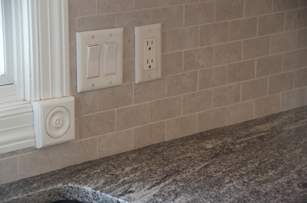 Mid-sized transitional u-shaped medium tone wood floor kitchen photo with an undermount sink, flat-panel cabinets, white cabinets, granite countertops, gray backsplash, subway tile backsplash, white appliances and an island