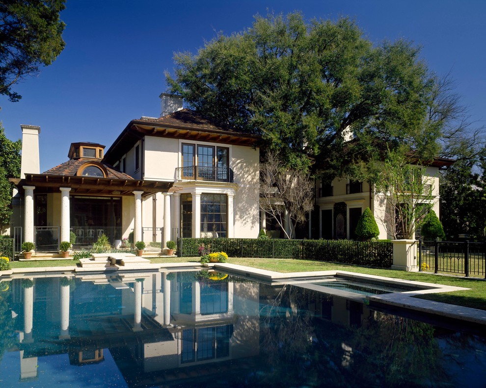Inspiration for a mediterranean two-storey exterior in Dallas with a hip roof.