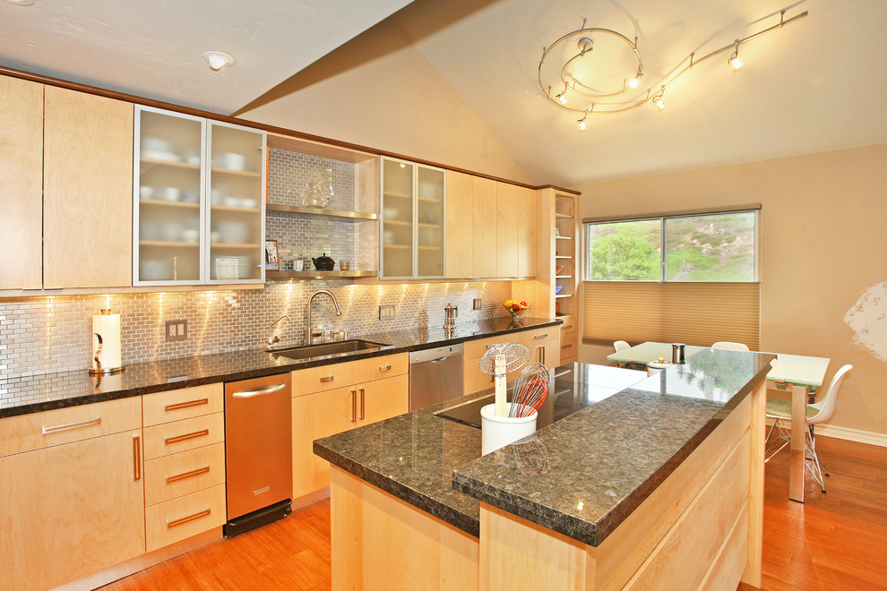 Photo of a large contemporary l-shaped eat-in kitchen in San Diego with an undermount sink, flat-panel cabinets, light wood cabinets, metallic splashback, metal splashback, stainless steel appliances, medium hardwood floors, with island and red floor.