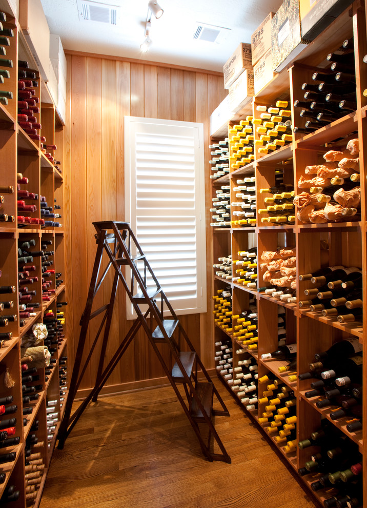 Mid-sized traditional wine cellar in Houston with medium hardwood floors and storage racks.