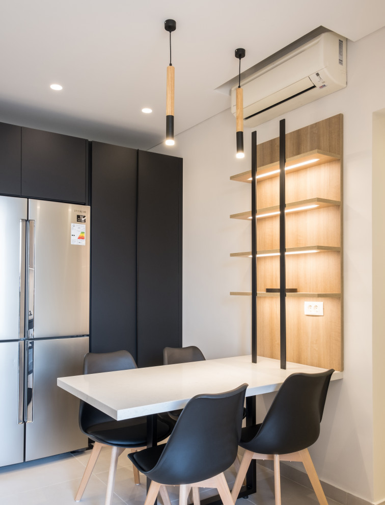 Inspiration for a mid-sized modern l-shaped eat-in kitchen in London with an integrated sink, black cabinets, quartz benchtops, white splashback, engineered quartz splashback, stainless steel appliances, limestone floors, no island, white benchtop and recessed.