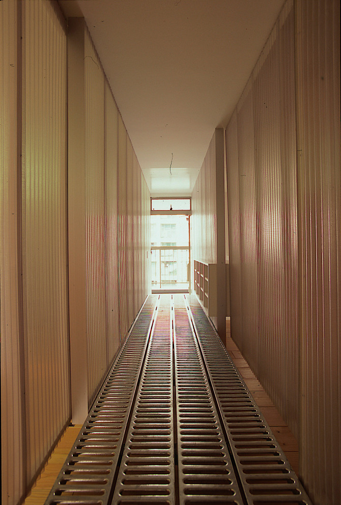 Photo of a small modern hallway in Tokyo Suburbs with grey floor and panelled walls.