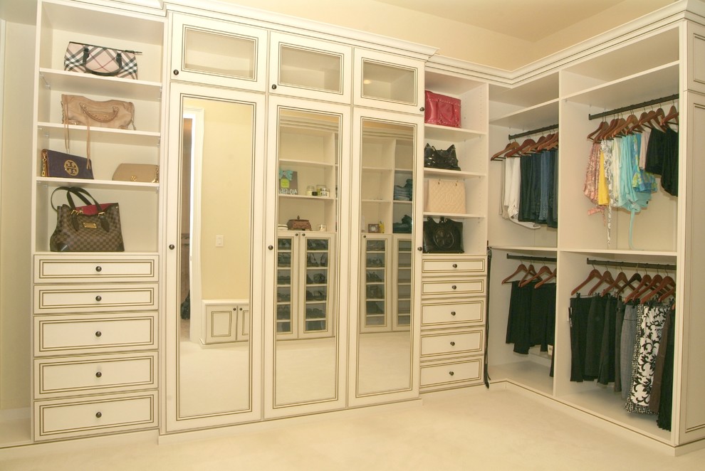 Photo of a large traditional women's walk-in wardrobe in Tampa with recessed-panel cabinets, white cabinets and carpet.
