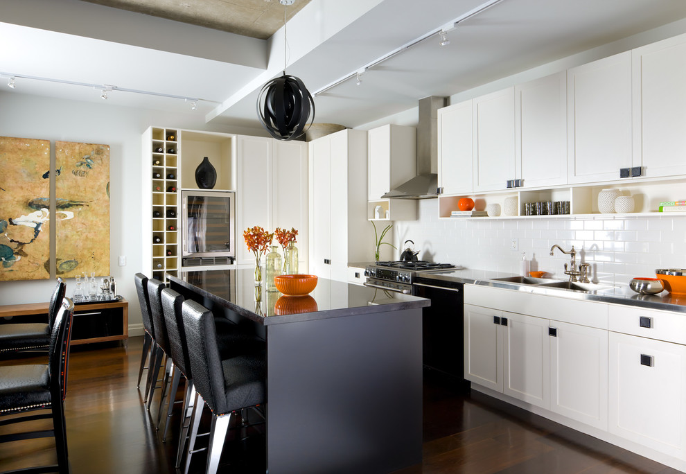 Photo of a transitional eat-in kitchen in Toronto with an integrated sink, shaker cabinets, stainless steel benchtops, white splashback, subway tile splashback, dark hardwood floors and with island.