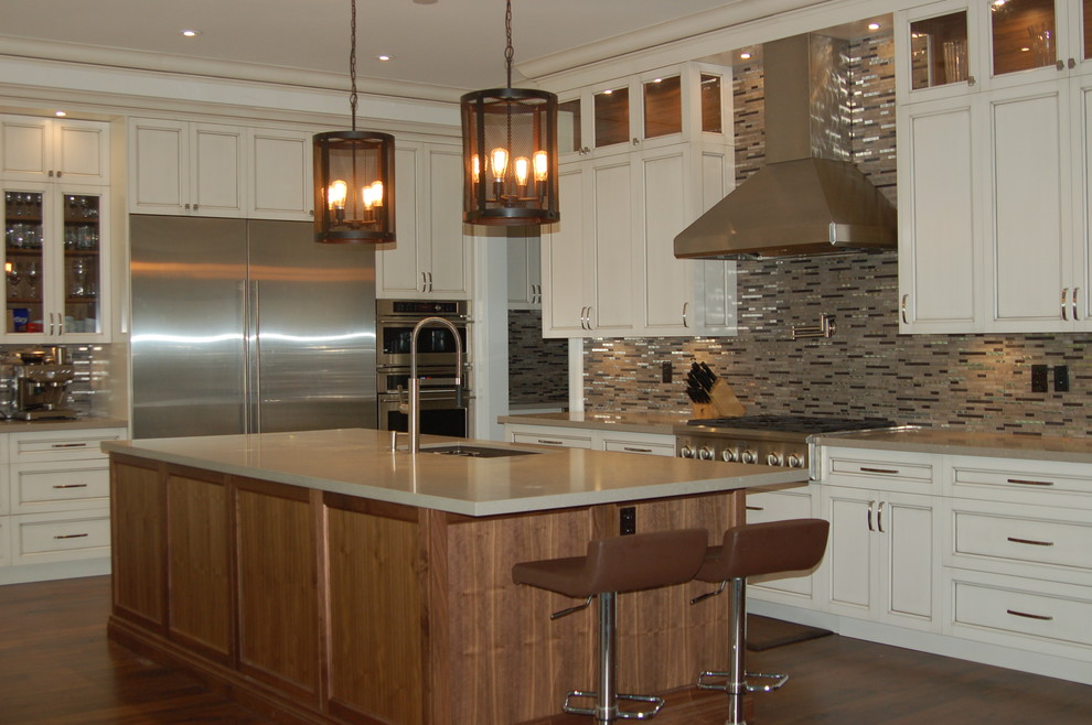 Open concept kitchen - large transitional l-shaped dark wood floor and brown floor open concept kitchen idea in Toronto with beaded inset cabinets, white cabinets, an island, an undermount sink, quartz countertops, metallic backsplash, matchstick tile backsplash, stainless steel appliances and beige countertops