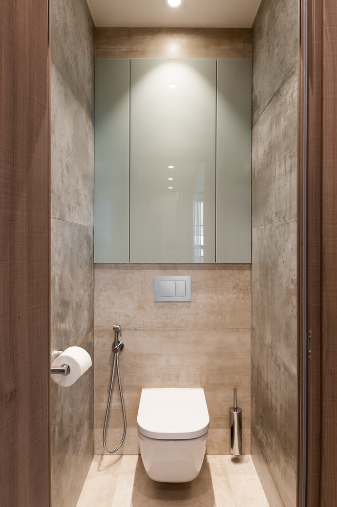 Photo of a mid-sized contemporary powder room in Saint Petersburg with glass-front cabinets, a wall-mount toilet, beige tile, porcelain tile, beige walls, porcelain floors and beige floor.