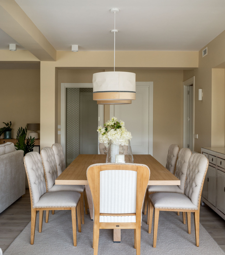 Foto de comedor tradicional renovado grande con paredes beige, suelo laminado, suelo beige y vigas vistas
