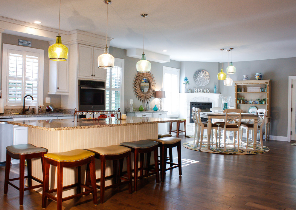 Example of a mid-sized transitional l-shaped medium tone wood floor open concept kitchen design in Baltimore with white cabinets, granite countertops, multicolored backsplash, matchstick tile backsplash, stainless steel appliances and an island
