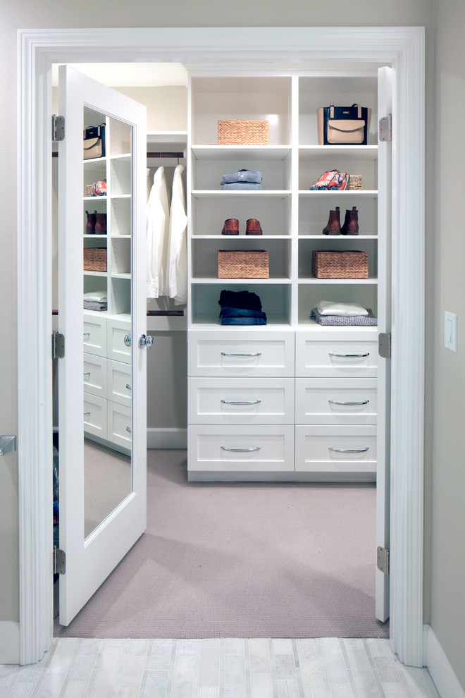 Design ideas for a mid-sized contemporary gender-neutral walk-in wardrobe in Other with shaker cabinets, white cabinets, carpet and beige floor.
