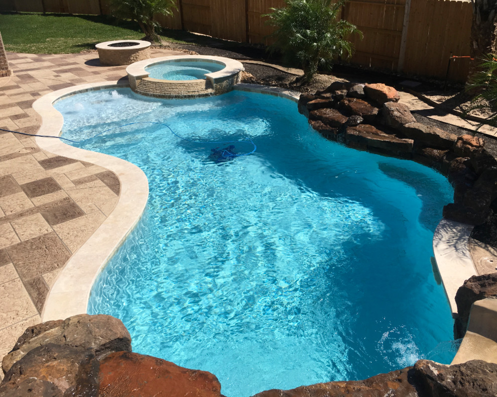 Large transitional backyard concrete paver and custom-shaped lap hot tub photo in Houston