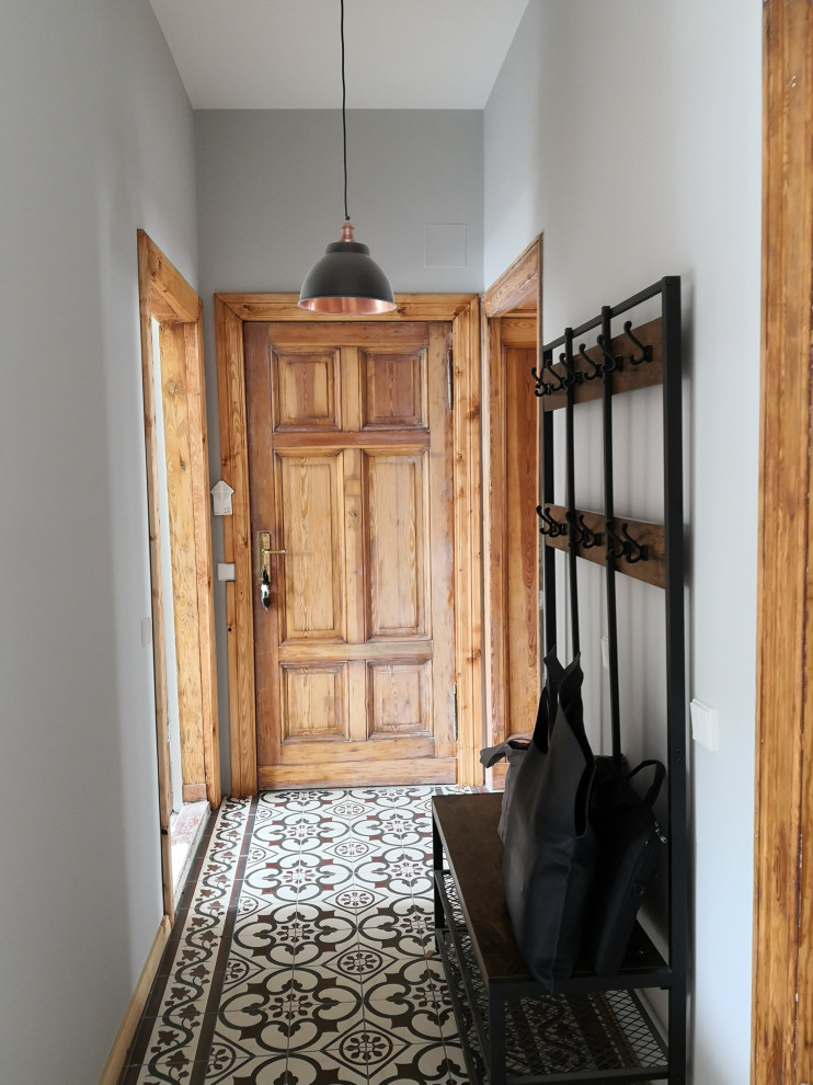 Stilmix Flur mit grauer Wandfarbe, Keramikboden und buntem Boden in Berlin